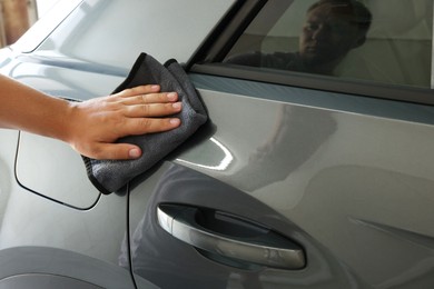 Man wiping auto with rag at car wash, closeup