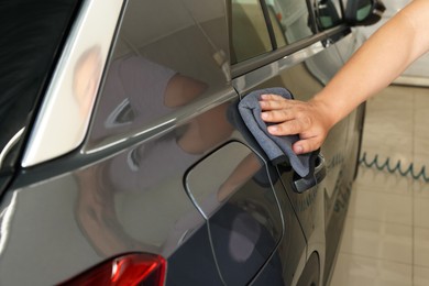 Man wiping auto with rag at car wash, closeup