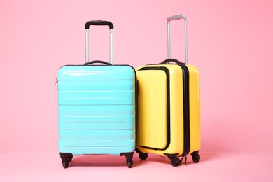 Photo of Two new color suitcases on pink background