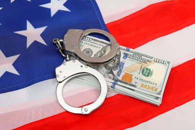 Handcuffs with dollar banknotes on American flag