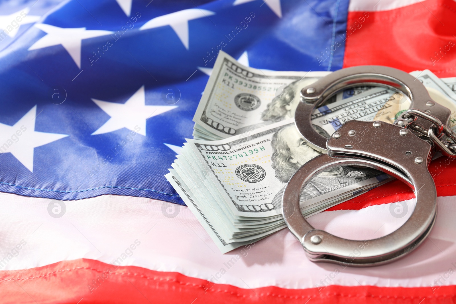 Photo of Handcuffs with dollar banknotes on American flag