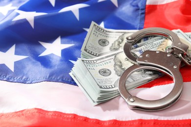 Handcuffs with dollar banknotes on American flag