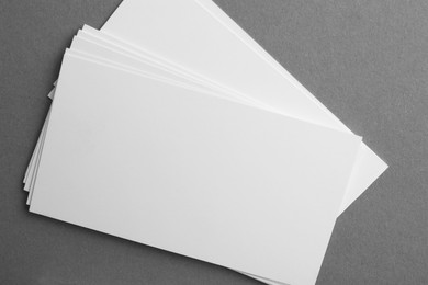 Blank business cards on grey background, top view. Mockup for design