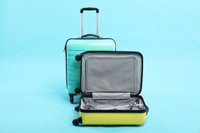 Photo of Two bright suitcases on light blue background