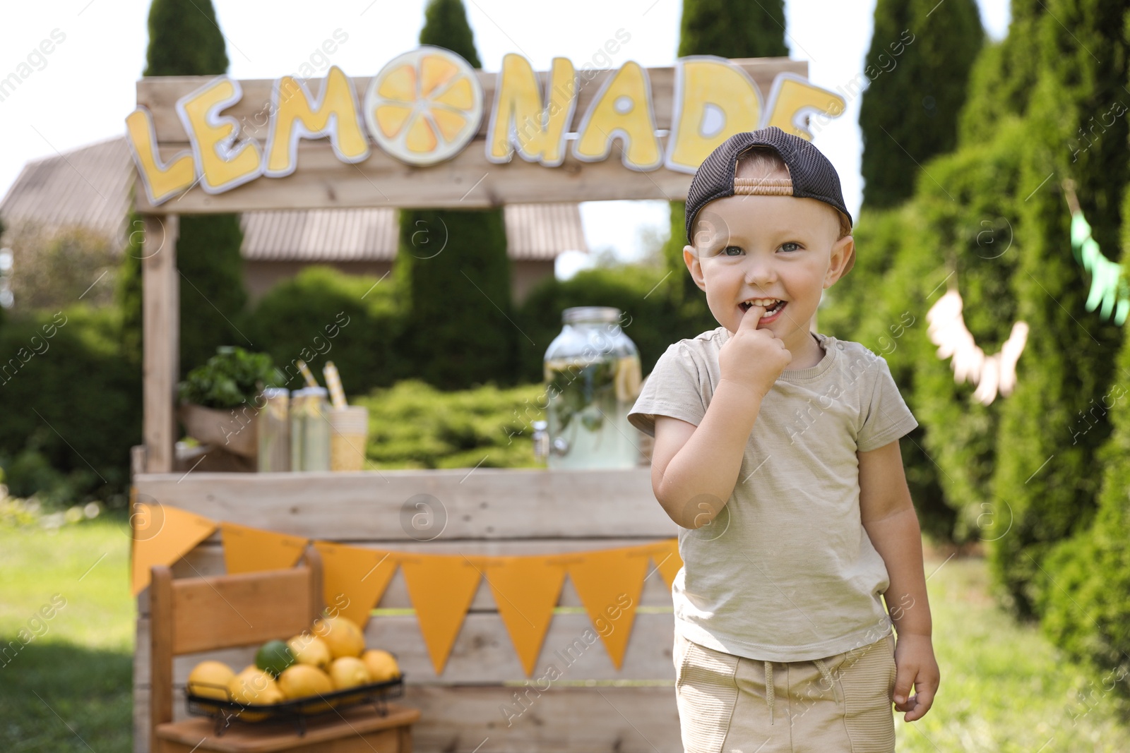 Photo of Cute little boy near lemonade stand in park