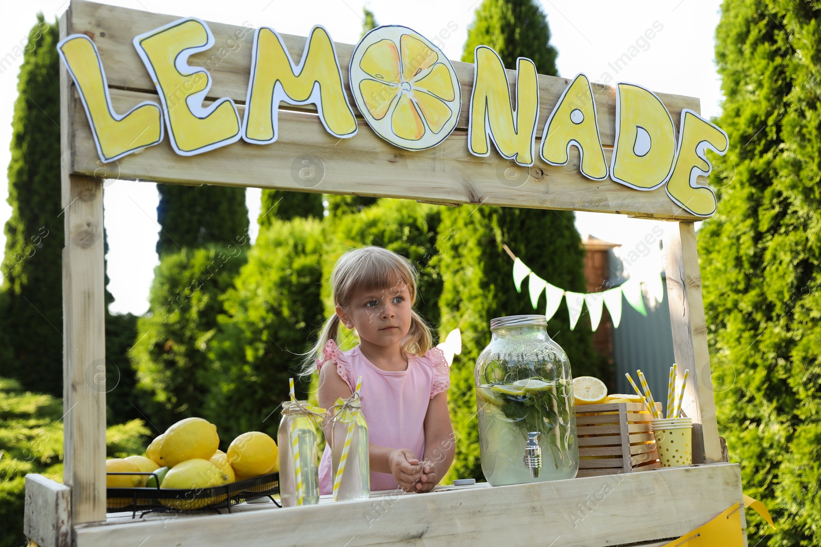 Photo of Cute little girl at lemonade stand in park