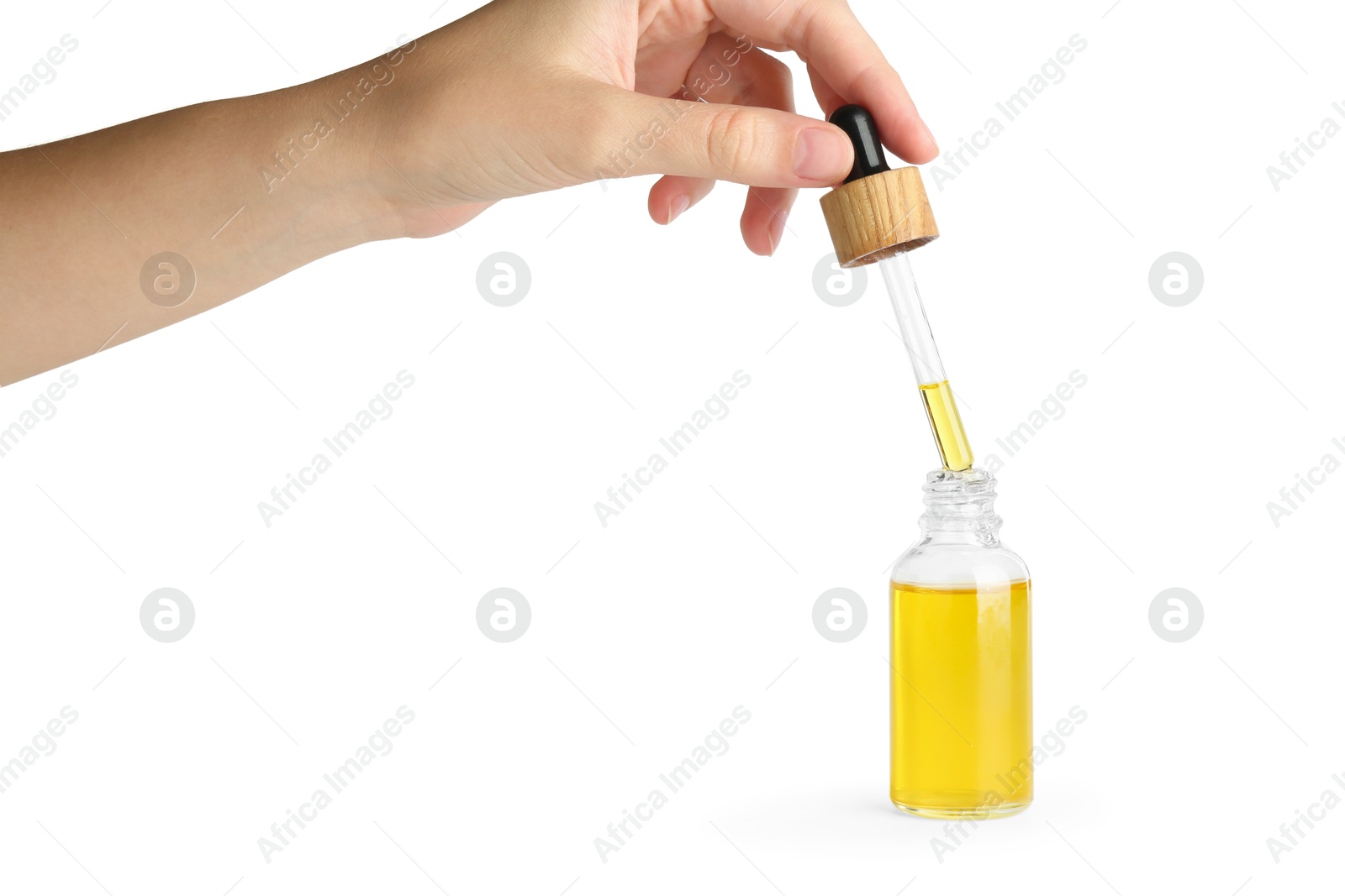 Photo of Woman dripping tincture from pipette into bottle on white background, closeup