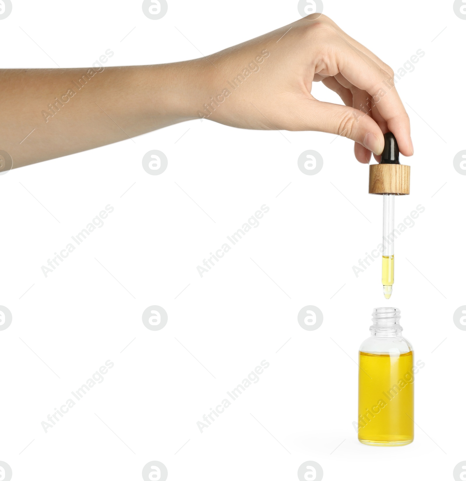 Photo of Woman dripping tincture from pipette into bottle on white background, closeup