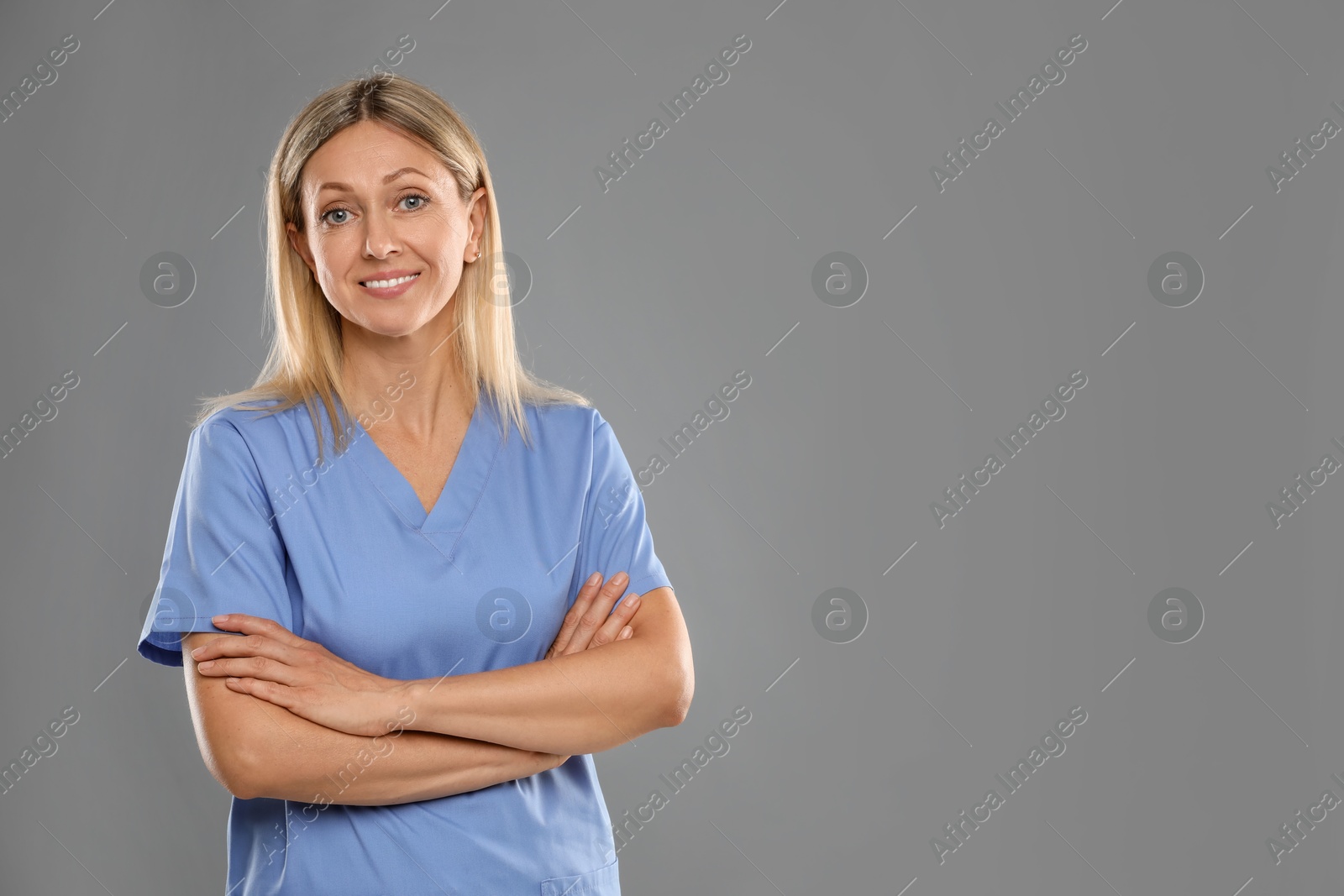 Photo of Portrait of nurse in medical uniform on grey background, space for text