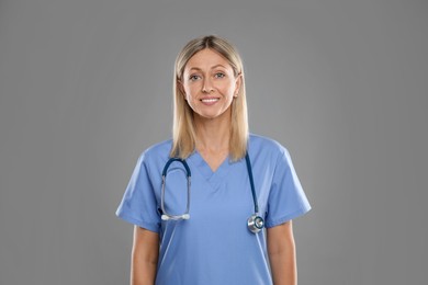 Photo of Portrait of doctor in medical uniform with stethoscope on grey background