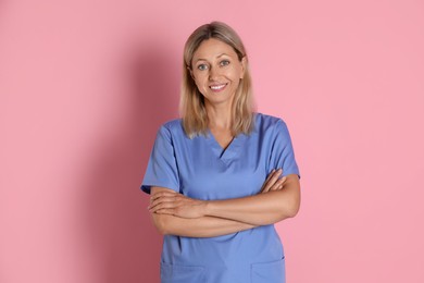 Portrait of nurse in medical uniform on pink background