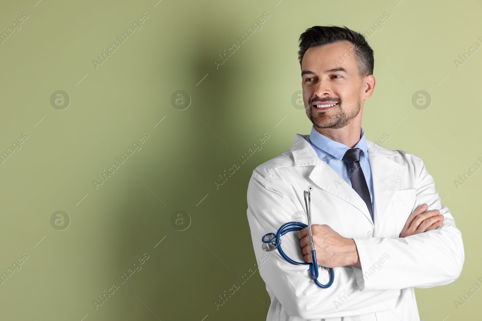 Photo of Smiling doctor with stethoscope on olive background. Space for text