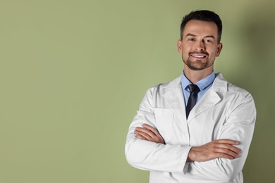 Photo of Portrait of smiling doctor on olive background, space for text