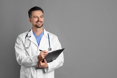 Photo of Smiling doctor with stethoscope and clipboard on grey background, space for text