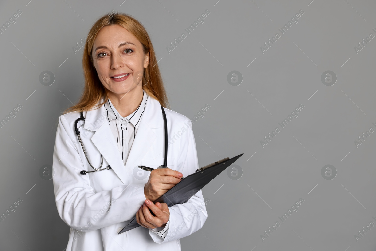 Photo of Doctor with clipboard writing notes on gray background, space for text