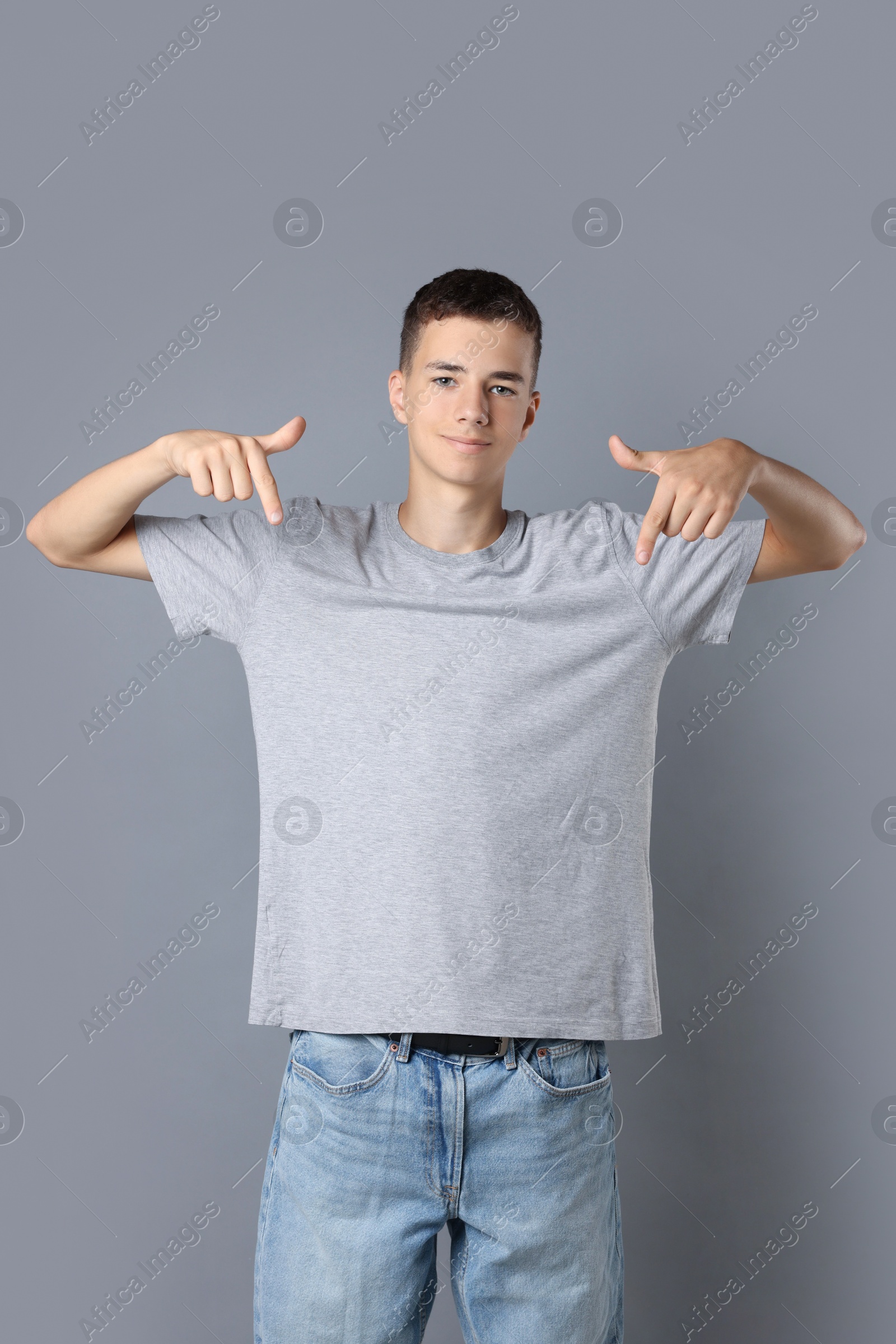 Photo of Teenage boy wearing t-shirt on grey background