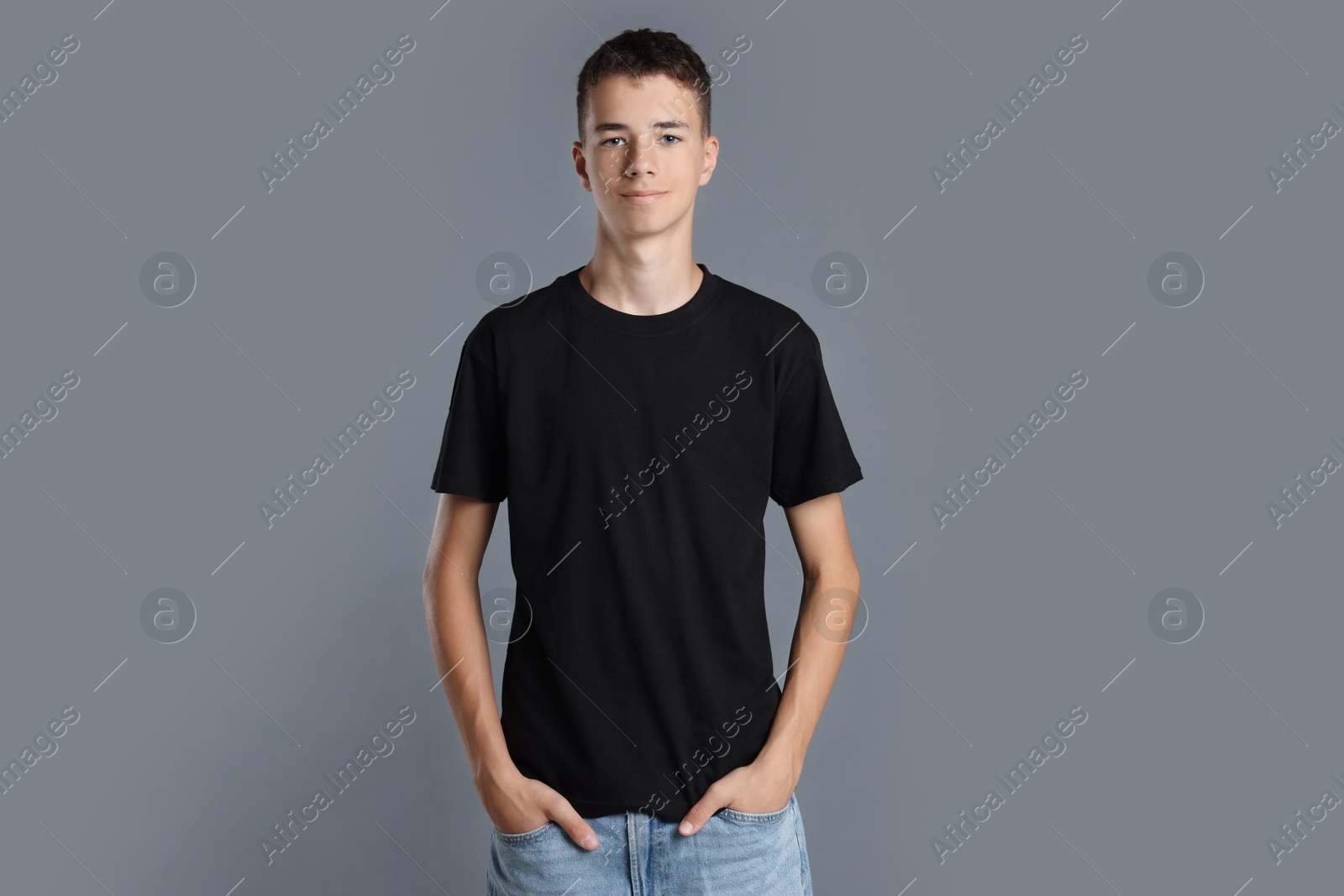 Photo of Teenage boy wearing black t-shirt on grey background