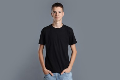 Teenage boy wearing black t-shirt on grey background