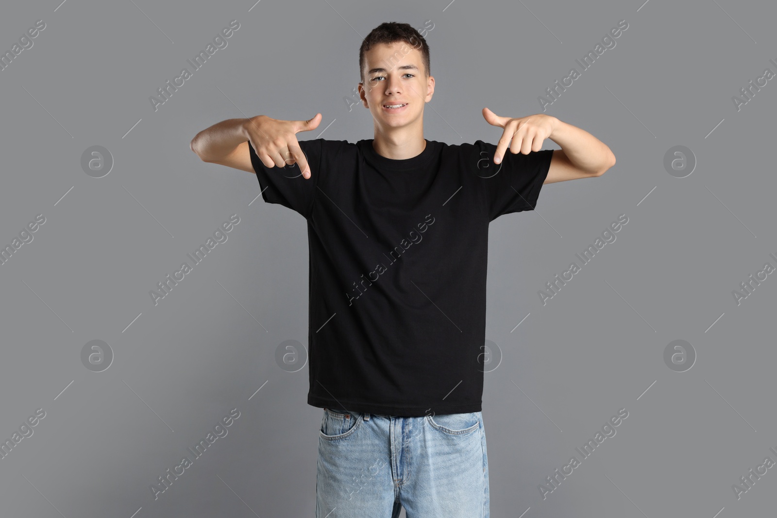 Photo of Teenage boy wearing black t-shirt on grey background