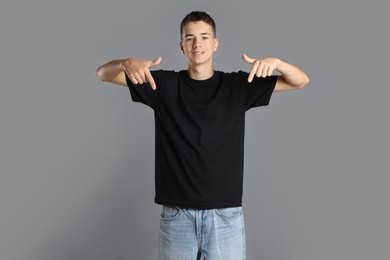 Teenage boy wearing black t-shirt on grey background