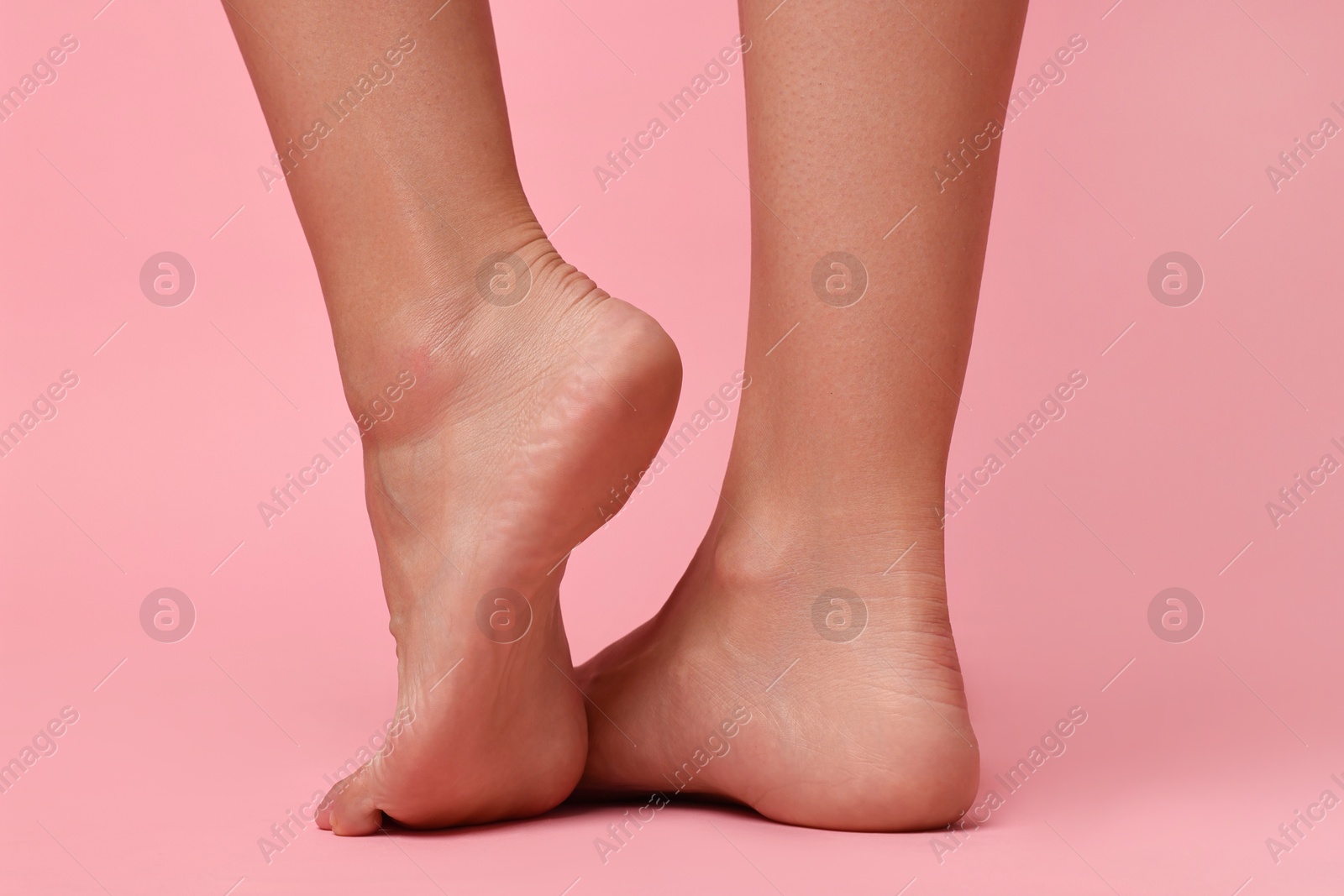 Photo of Woman with smooth feet on pink background, closeup