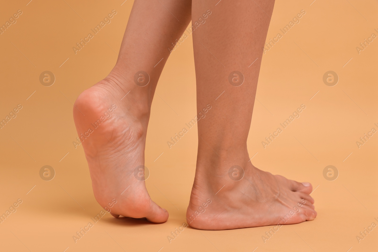 Photo of Woman with smooth feet on beige background, closeup