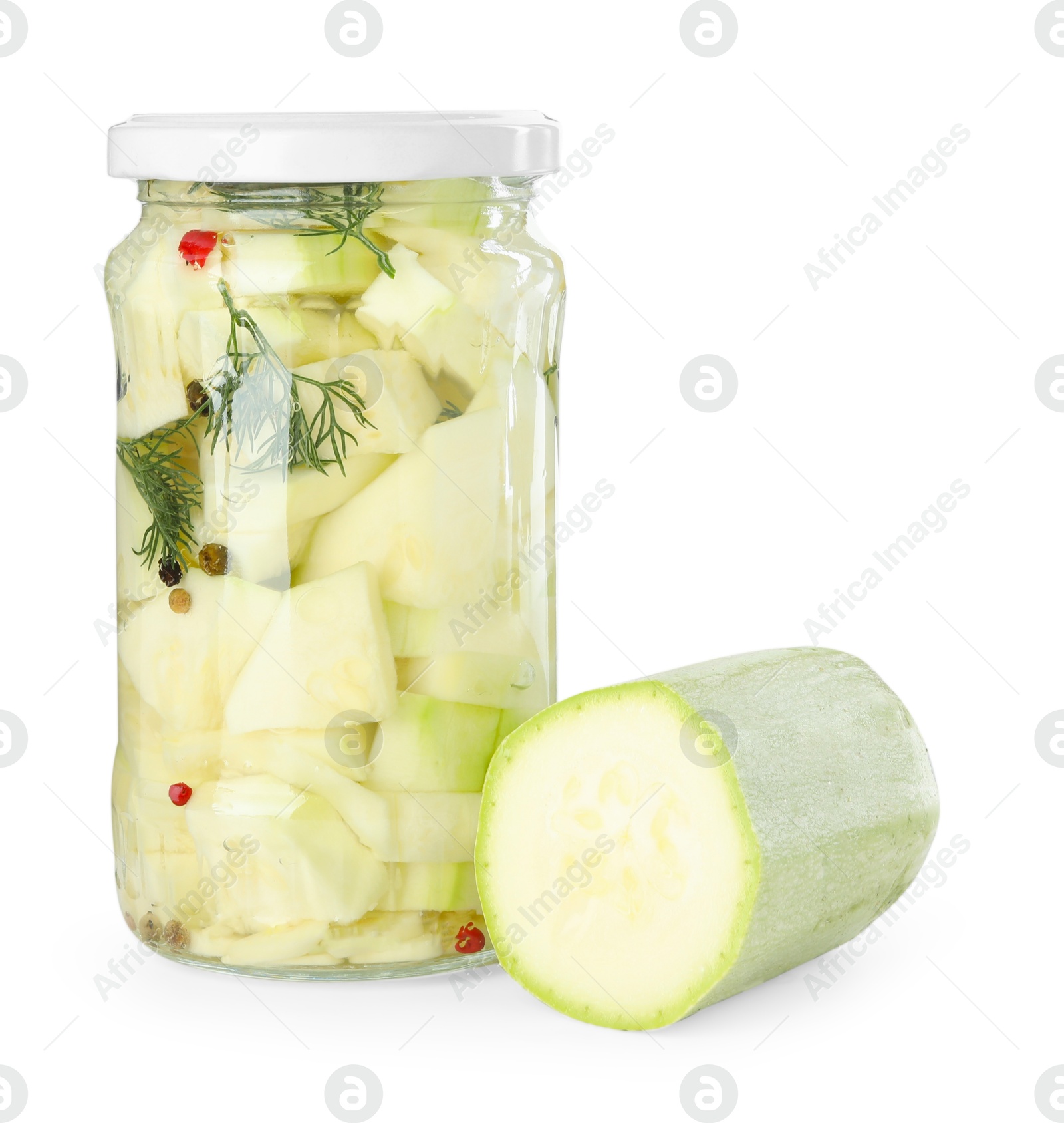 Photo of Tasty pickled zucchinis in jar and fresh vegetable isolated on white