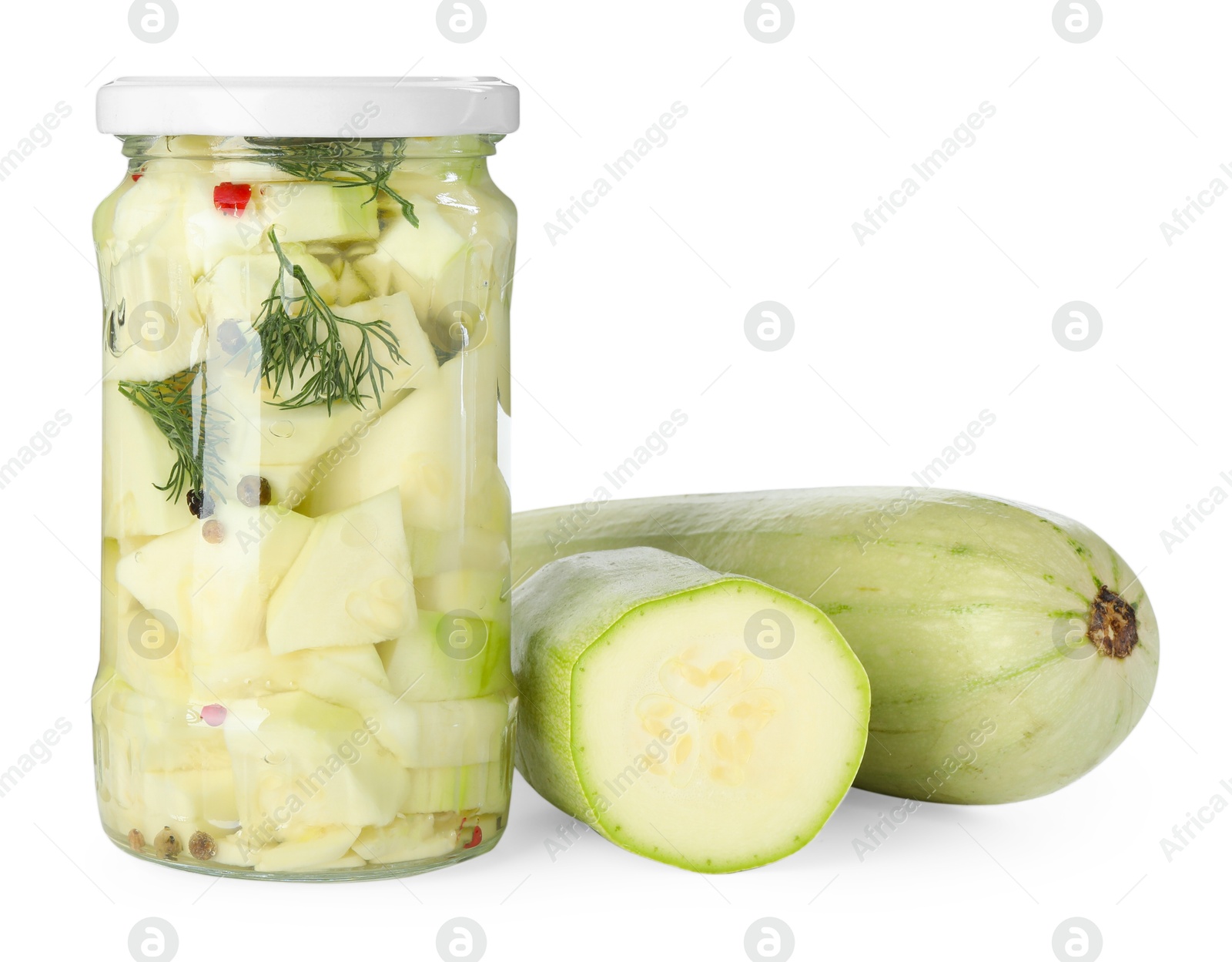 Photo of Tasty pickled zucchinis in jar and fresh vegetables isolated on white