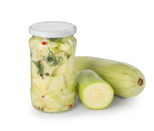 Photo of Tasty pickled zucchinis in jar and fresh vegetables isolated on white