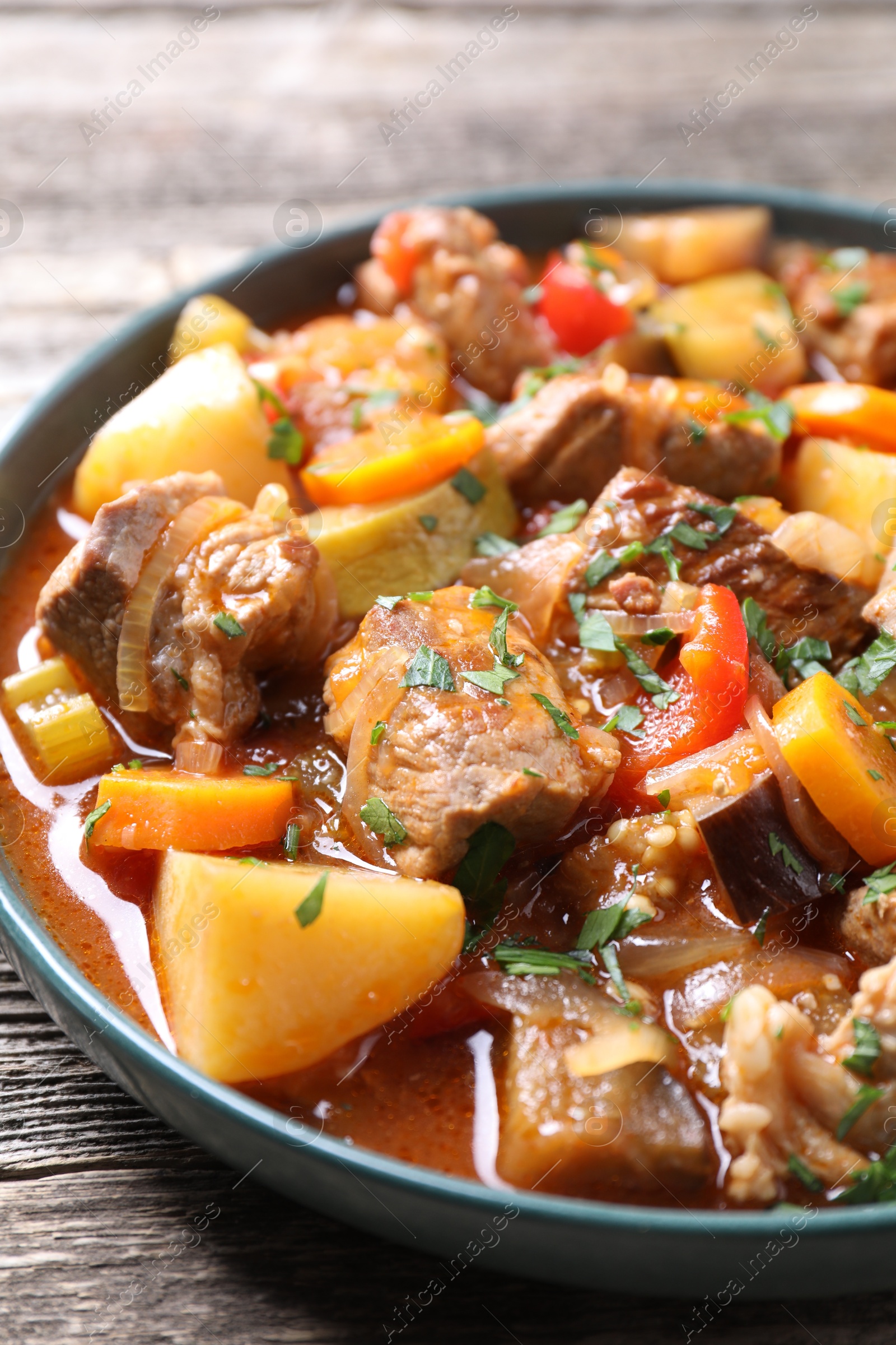 Photo of Delicious stew with vegetables on wooden table, closeup