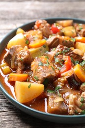 Delicious stew with vegetables on wooden table, closeup