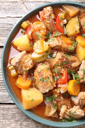 Photo of Delicious stew with vegetables on wooden table, top view