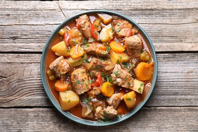 Delicious stew with vegetables on wooden table, top view