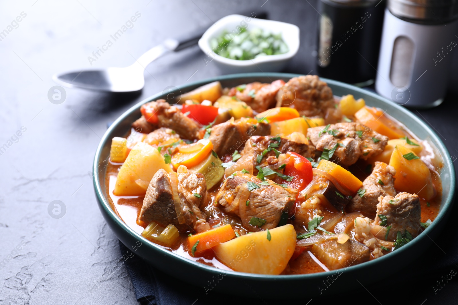 Photo of Delicious stew with vegetables on black table, closeup