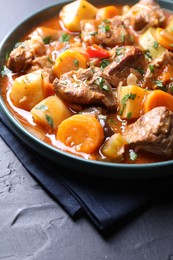 Photo of Delicious stew with vegetables on black table, closeup