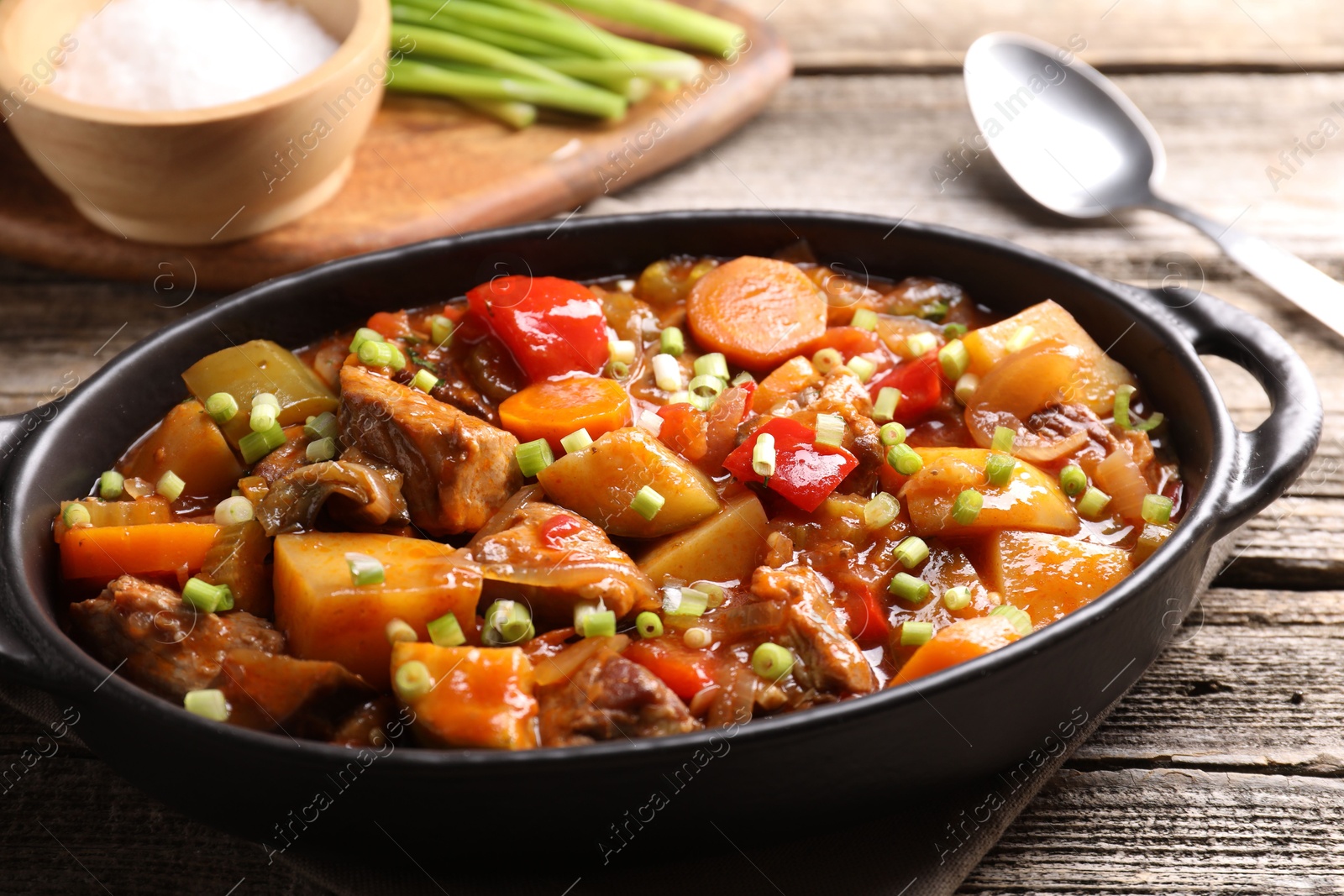 Photo of Delicious stew with vegetables in baking dish on wooden table, closeup