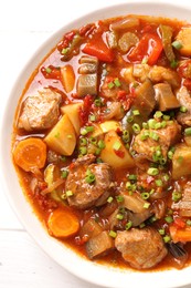 Delicious stew with vegetables in bowl on table, top view