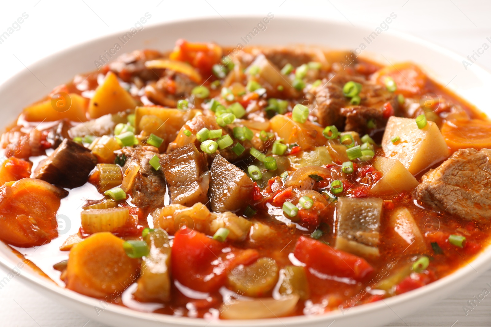 Photo of Delicious stew with vegetables in bowl on table, closeup