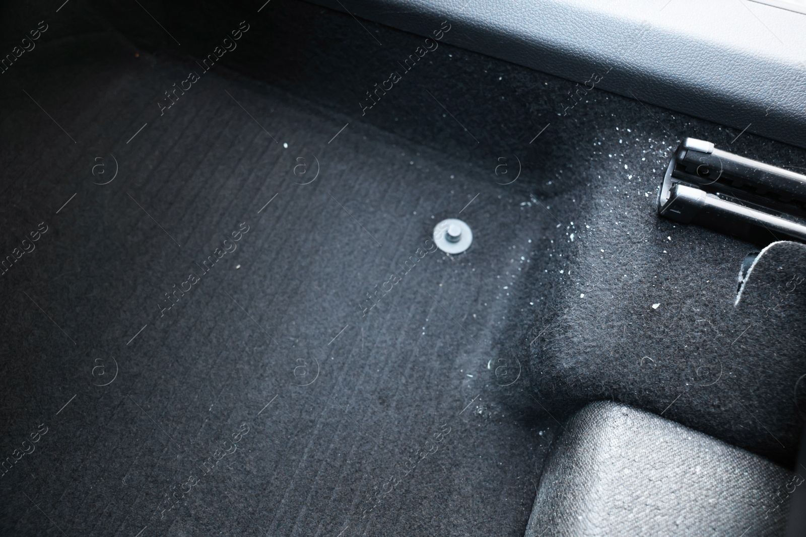 Photo of Black soft car floor mat in auto, closeup