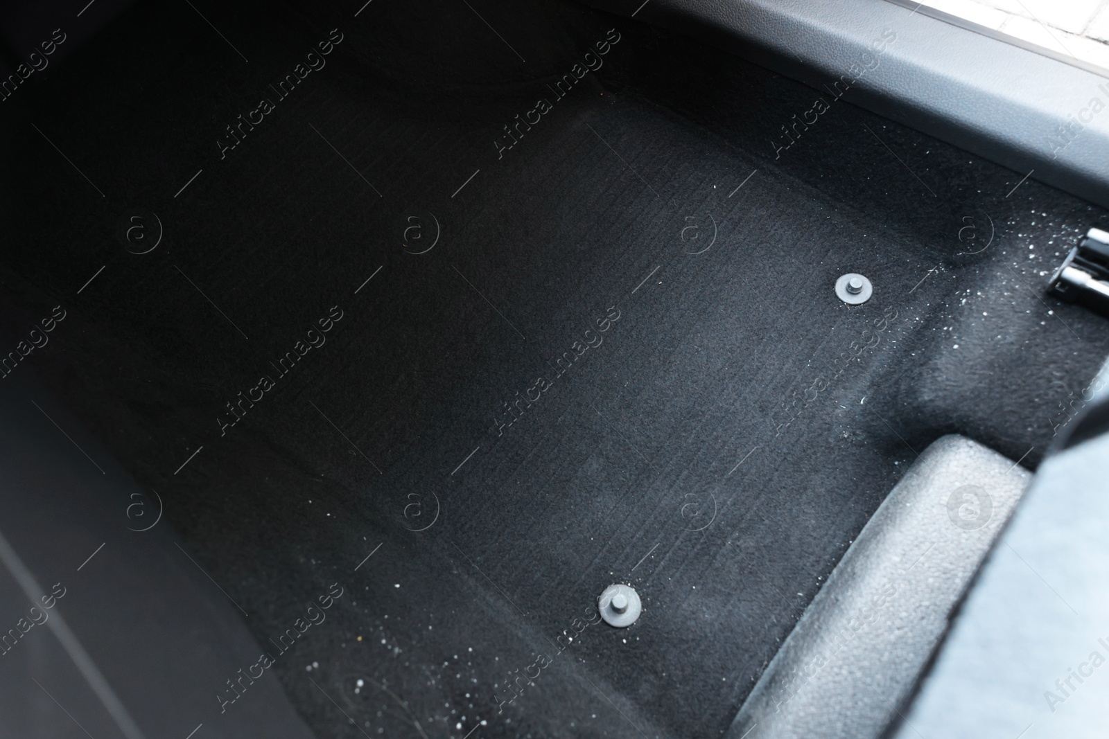 Photo of Black soft car floor mat in auto, closeup