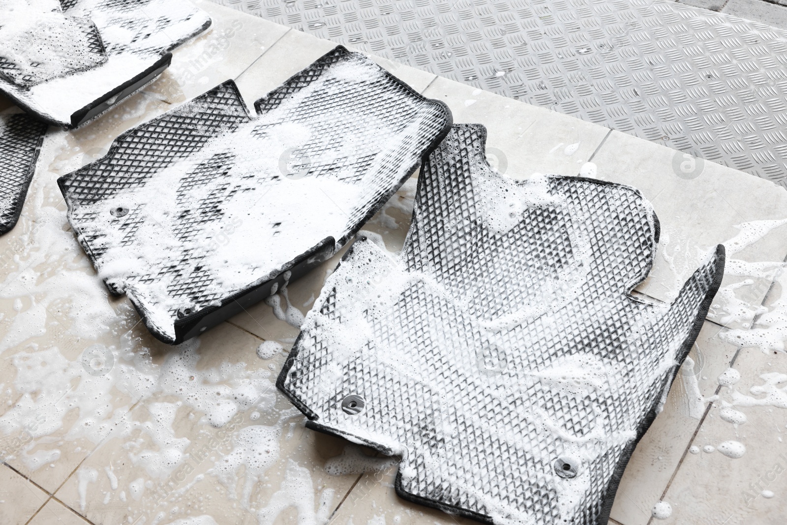 Photo of Car floor mats covered with foam indoors