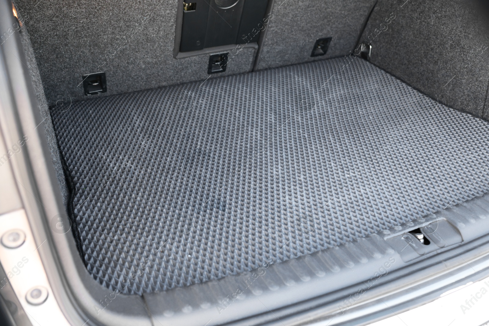 Photo of Grey rubber car boot liner mat in trunk of auto