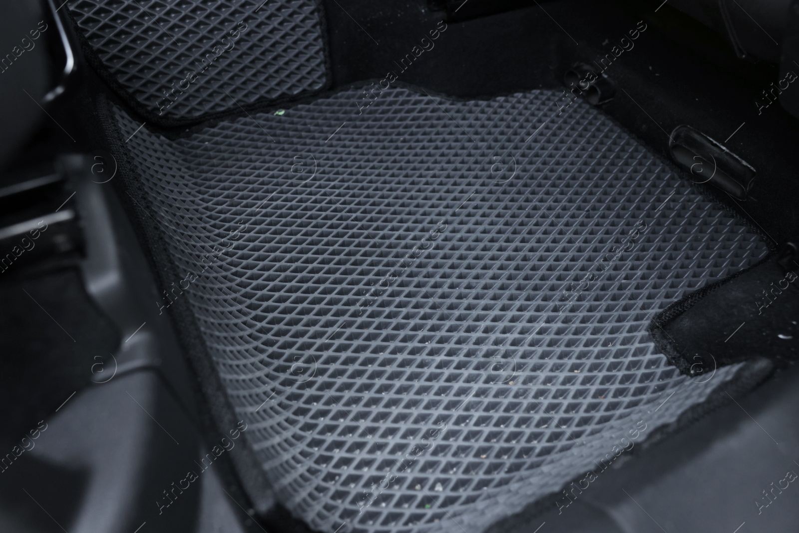 Photo of Grey rubber car floor mat in auto, closeup