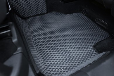 Photo of Grey rubber car floor mat in auto, closeup