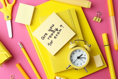 Photo of Paper note with question Are You Ready For Exam and stationery on pink background, flat lay