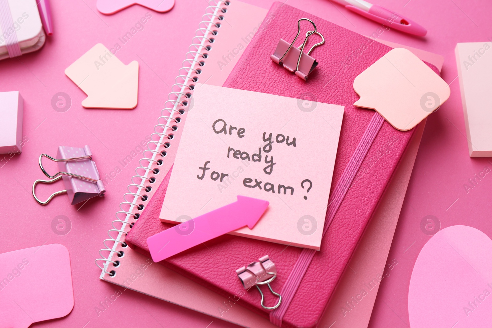 Photo of Paper note with question Are You Ready For Exam and stationery on pink background, above view