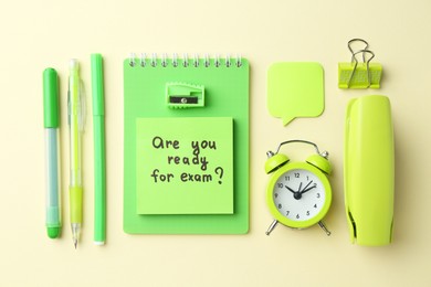 Paper note with question Are You Ready For Exam and stationery on pale yellow background, flat lay