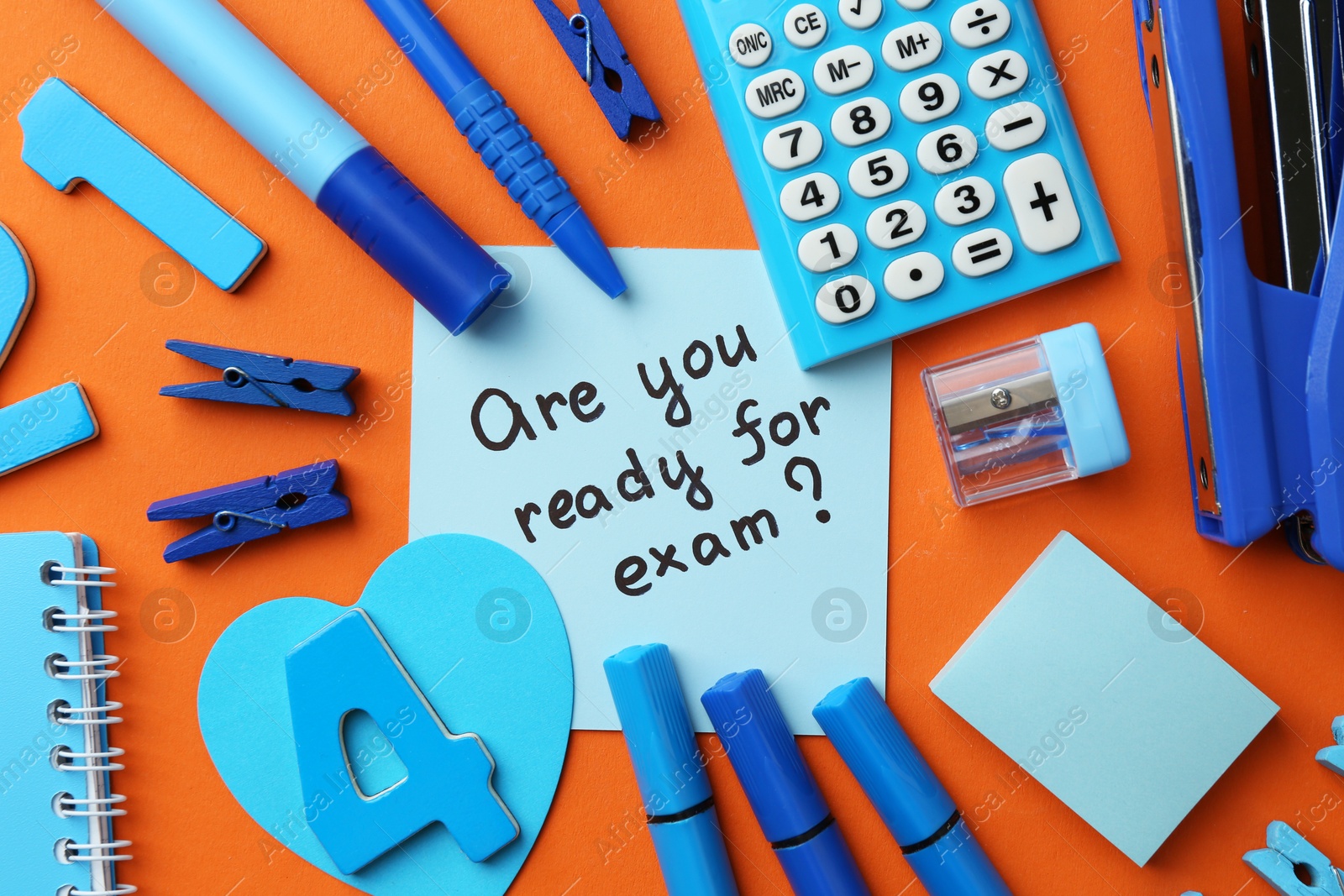 Photo of Paper note with question Are You Ready For Exam and stationery on orange background, flat lay