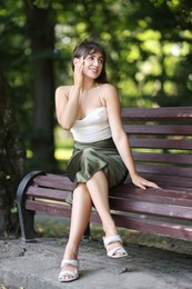 Photo of Smiling woman sitting on bench in park