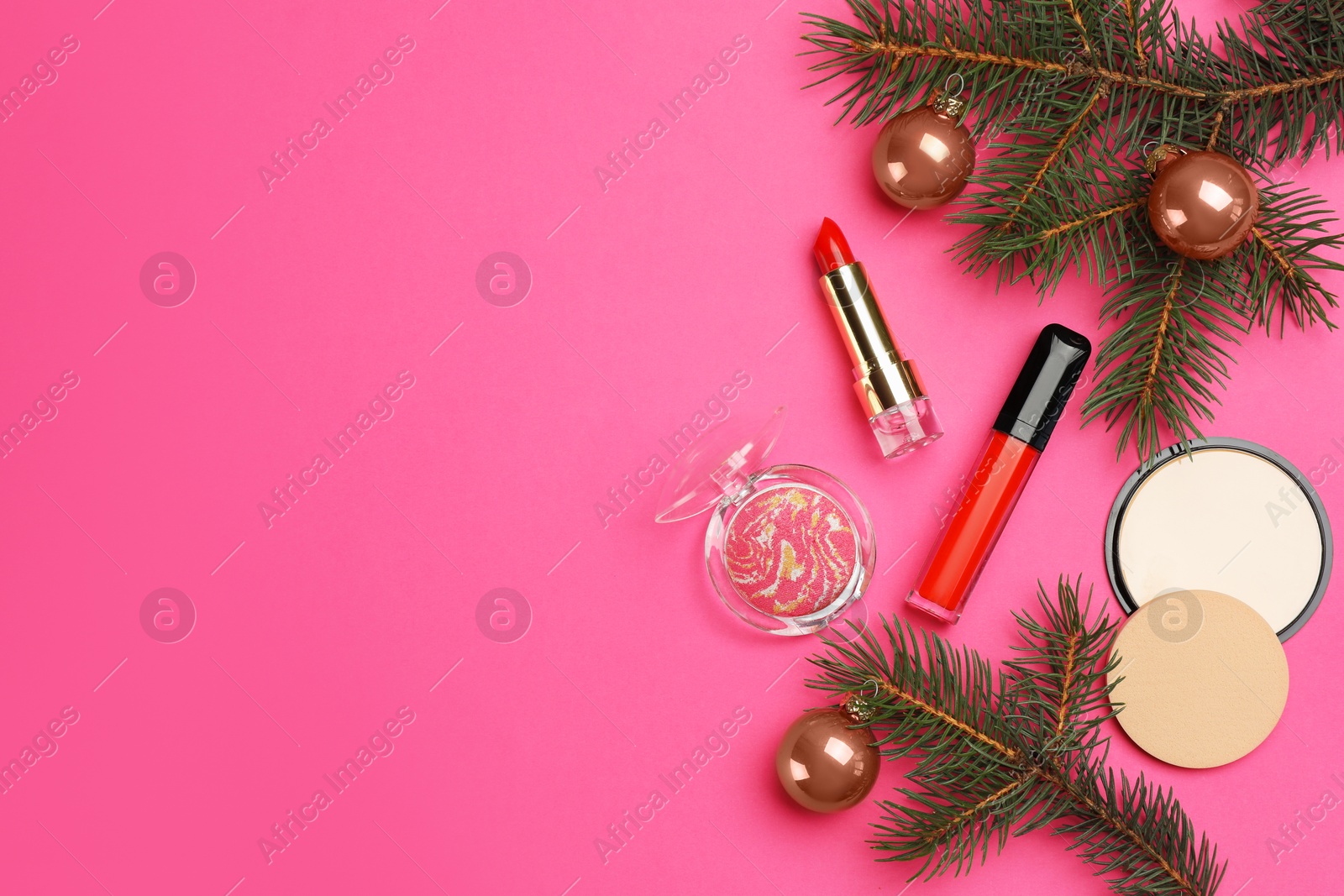 Photo of Flat lay composition with makeup products and Christmas decor on pink background. Space for text